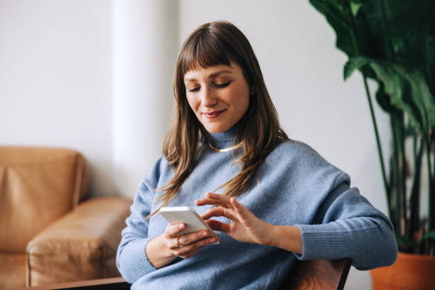istock Businesswoman using a mobile phone in an office lobby 1445944475