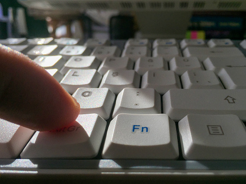 Using computer. Close-up a finger pushing computer keyboard
