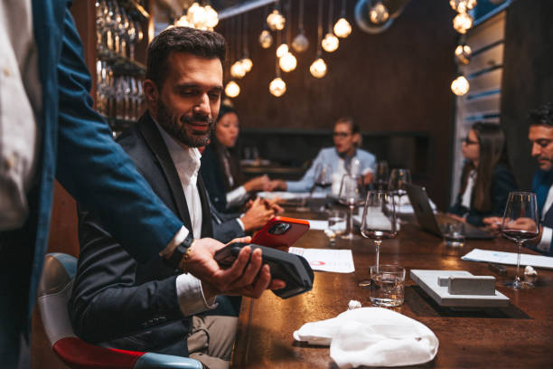 Businessman paying job lunch using contactless mobile app payment stock photo