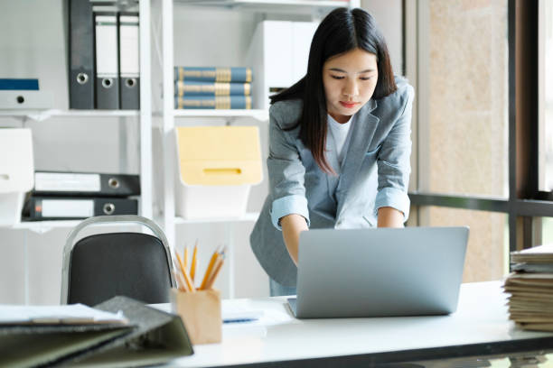 istock Young asian businesswoman working at office using laptop. 1445954296
