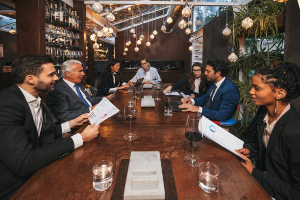 business meeting in a luxury restaurant. group of multi ethnic and diverse age range people attending to a corporate briefing - chinese ethnicity latin american and hispanic ethnicity multi ethnic group business person imagens e fotografias de stock
