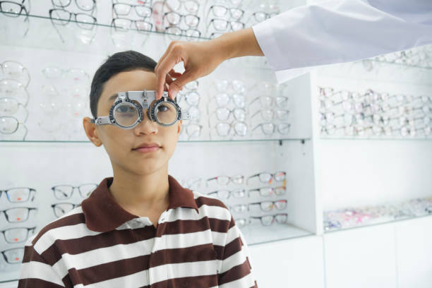 istock Young boy examining eyesight in optical clinic. 1445954738