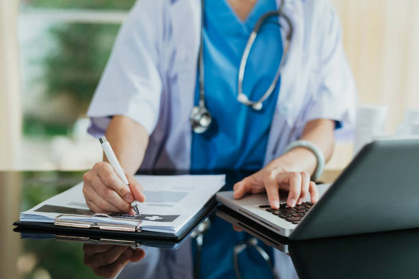istock Medical technology concept. Doctor working with mobile phone and stethoscope and digital tablet laptop in modern office at hospital in morning light 1445956643