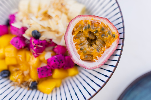 Bowl with banana, dragon fruit, blueberries and passion fruit