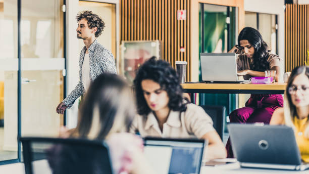 istock One coworker passing by the office tables 1445969369
