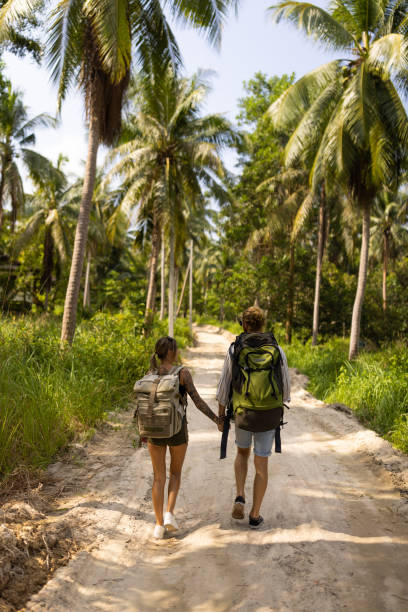 istock Caucasian couple, holding hands while walking through rainforest 1445970204