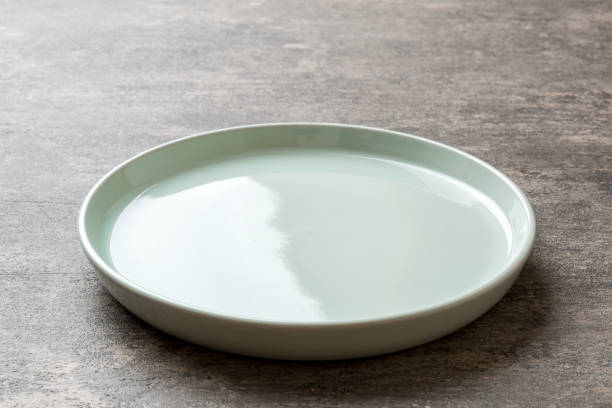 istock Perspective view of empty blue plate on cement background. Empty space for your design 1445970224