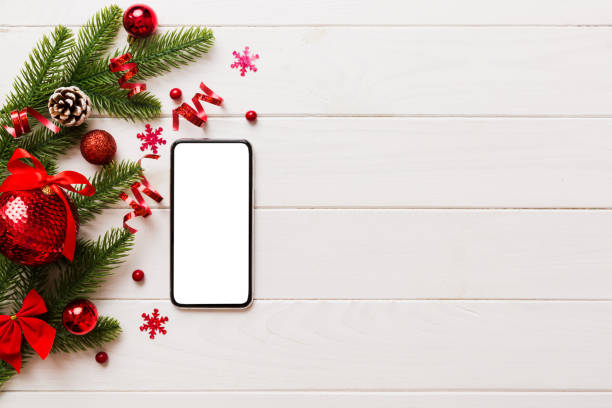 istock Digital phone mock up with rustic Christmas decorations for app presentation top view with empty space for you design. Christmas online shopping concept. Tablet with copy space on colored background 1445970275