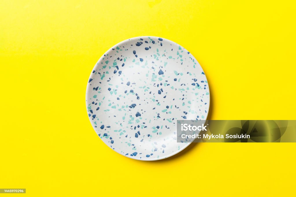 Top view of isolated of colored background empty round blue plate for food. Empty dish with space for your design Top view of isolated of colored background empty round blue plate for food. Empty dish with space for your design. Plate Stock Photo