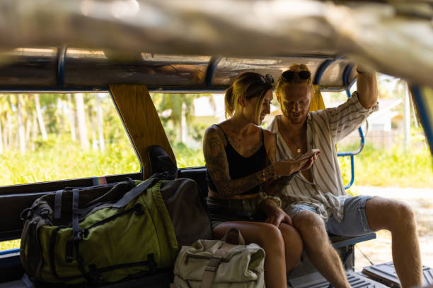 istock Couple using mobile phone, while riding in the off road taxi 1445970605