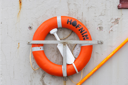 lifebuoy along the quay of the harbor in the Icelandic port of Höfn; Höfn, Iceland