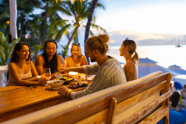 istock Multiracial friends enjoy the dinner at the beach restaurant during sunset 1445976201
