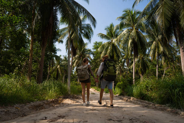 istock Caucasian couple, holding hands while walking through rainforest 1445976289