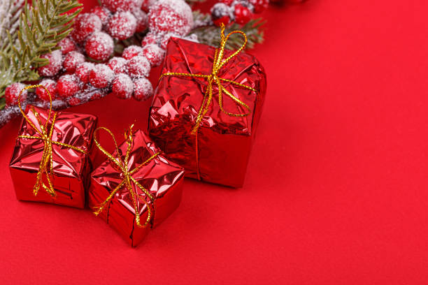 istock Christmas tree branch with toys and a gift on a red background 1445976458