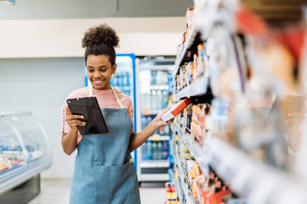 Employee in supermarket using digital tablet to organize delivery for supply chain stock photo