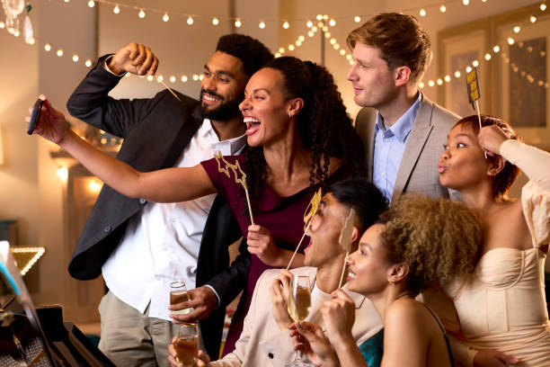 Grupo de amigos posando para selfie ao redor do piano comemorando na festa de Ano Novo juntos - foto de acervo