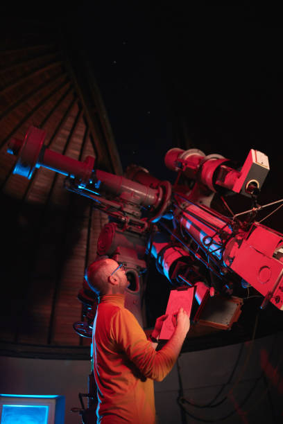 istock Astronomer with a big astronomical telescope in observatory doing science research of space and celestial objects. 1445980022