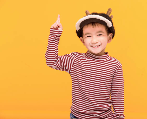 istock Happy kid dressed in christmas  hat and pointing up 1445981327