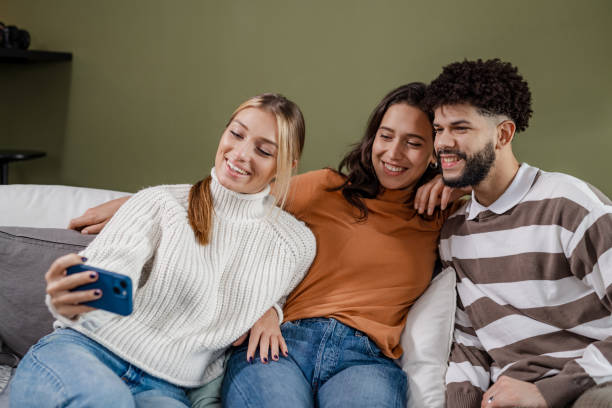 istock Young people sitting on the couch and taking a selfie 1445981648