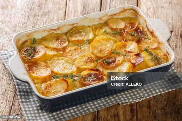 Scalloped Potatoes Potato Casserole With The Addition Of Herbs Onion And Garlic In A Ceramic Baking Dish Closeup Horizontal Stock Photo - Download Image Now