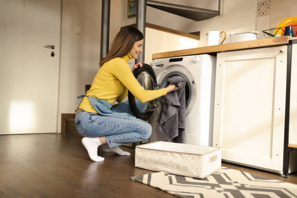 istock Young woman putting dirty laundry into a machine 1445982037