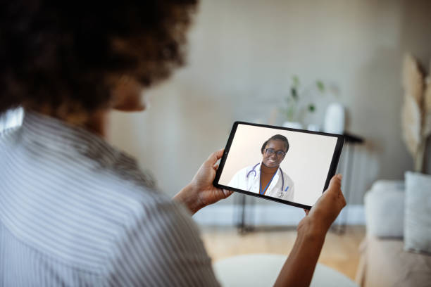 istock Unrecognisable African-American woman using digital device to get advice from GP, talking to doctor on video call 1445985074