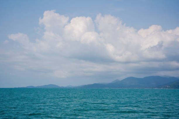 istock Island hills under fluffy clouds 1445987999