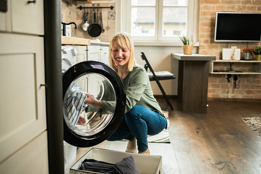 Portrait of a beautiful, young woman doing her laundry at home