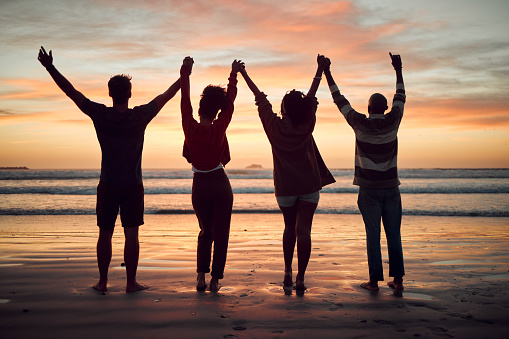 Beach, celebration and friends silhouette, sunset horizon and ocean for night, youth and adventure lifestyle. Freedom, group people shadow holding hands in dark sea with orange background mock up