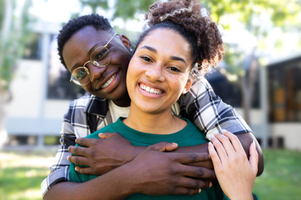 Young black loving couple embracing outdoors looking at camera. Loving relationship.