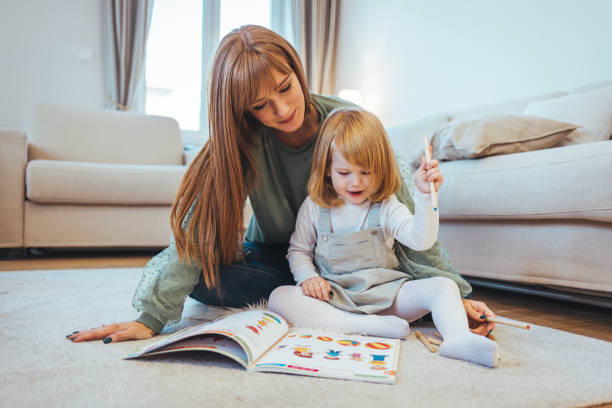 istock Mother teaching small daughter to drawing reading and writing 1445998621