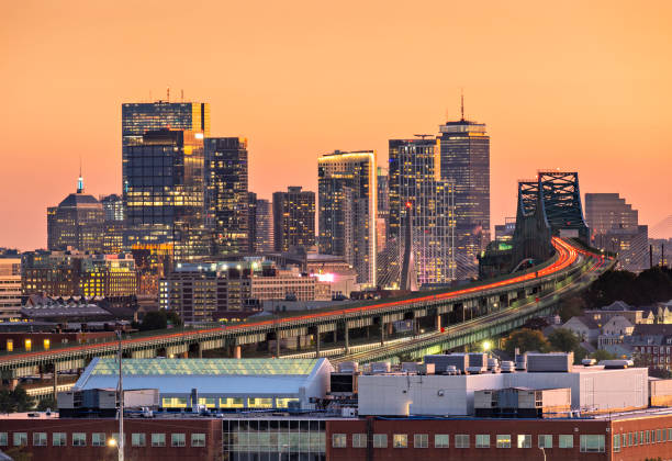 chaude lueur de coucher de soleil sur les toits du centre-ville de boston à twilight, massachusetts, états-unis - boston skyline night city photos et images de collection