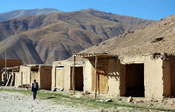 Village between Kabul and Bamyan (Bamiyan) / Afghanistan: A man walks along the road through this remote village in central Afghanistan on the southern route between Kabul and Bamyan.