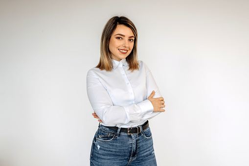 Portrait of young beautiful woman wearing button down shirt against white background