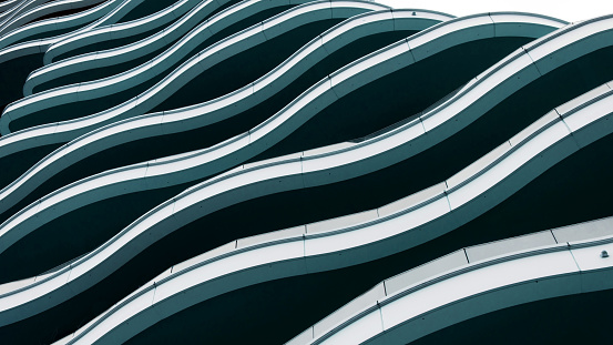 Modern building with wave shaped exterior. Modern future architecture. Low angle view of building floors.