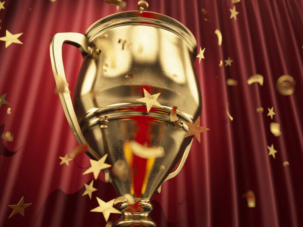 istock Winning a Championship Concept Golden Trophy Cup with Star Shaped Confetti 1446014423
