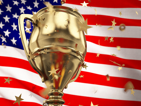 Championship Concept Star Shaped Confetti Falling Onto A Gold Trophy Cup with American Flag. 3D Render