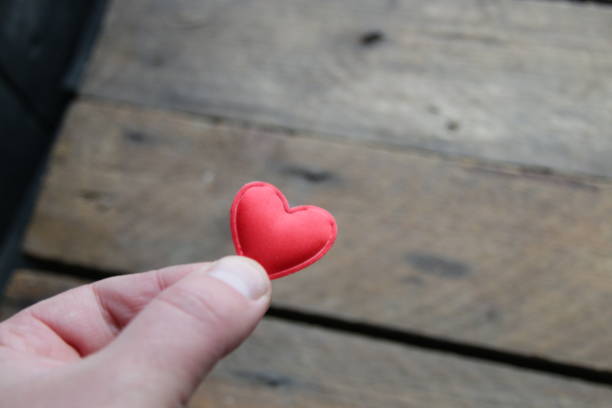 istock Hand holding heart on vintage table background 1446014734