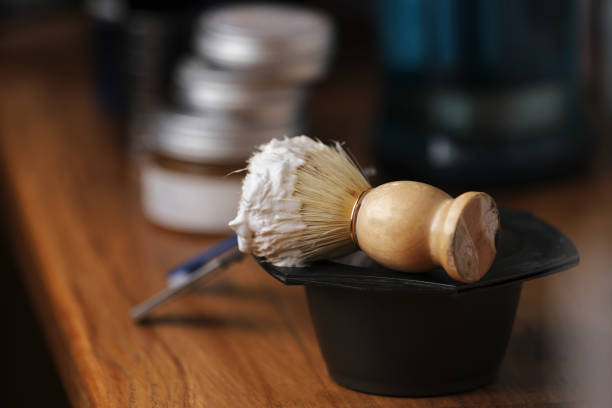 Set of shaving equipment and men's cosmetic products on wooden table, barbershop. shave concept with a straight razor, shaving brush and foam. beard care products for men on background conjunto de equipos de afeitado y productos cosméticos para hombres sobre mesa de madera, barbería. concepto de afeitado con una maquinilla de afeitar recta, cepillo de afeitar y espuma. productos para el cuidado de la barba para hombres en el fondo.