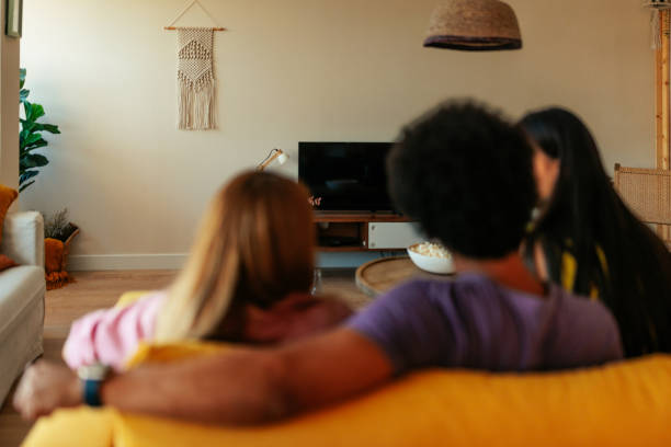 istock Friends in living room watching tv. 1446024445