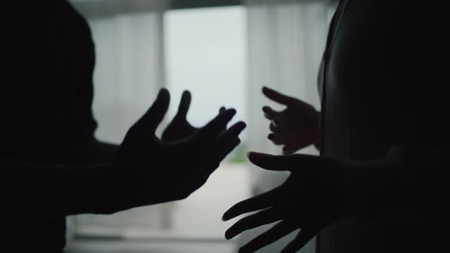 Close-up hands of unhappy african ethnicity couple fighting and yelling in the living room. Relationship crisis