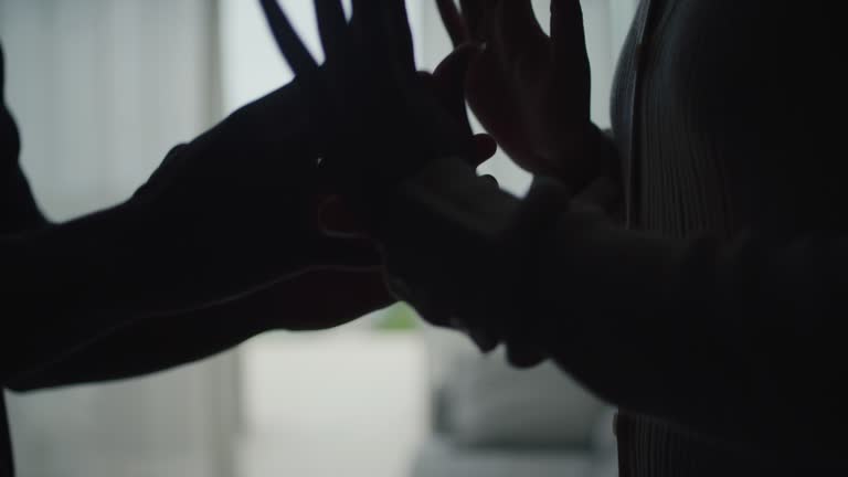 Close-up hands of unhappy african ethnicity couple fighting and yelling in the living room. Pointing and gesturing