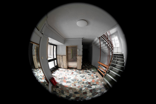 Empty corridor, floor, stairways and two neighboring doors are visible through the door peephole