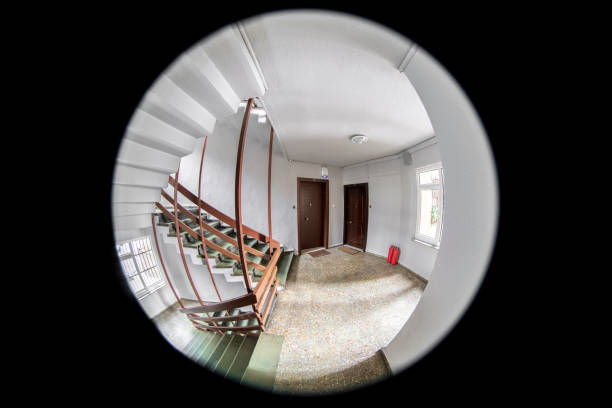 Looking through peephole in an apartment Empty corridor, floor, stairways and two neighboring doors are visible through the door peephole fish eye lens stock pictures, royalty-free photos & images