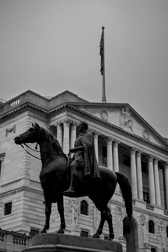 London Financial district on a foggy day in November 2022. The inscription on the statue reads;\nOn 19th July 1838 the Court of Common Council of the City of London agreed to a contribution of £500 toward the cost of the above statue of the Duke of Wellington in appreciation of his efforts in assisting the passage of the London Bridge Approaches Act 1827. This Act led to the creation of King William Street. The government donated the metal, which is bronze from captured enemy cannon melted down after the Battle of Waterloo, and valued at the time at £1500. The total cost of the statue was £9000. The remainder being raised by public subscription.\nThe sculptor, Sir Francis Chantrey (1781 to 1841), was commissioned in 1838 but died before the work was completed. It was finished by his assistant Henry Weekes (1807 to 1877).\nThe Lord Mayor, William Magnay, unveiled the statue on 18th June 1844, the anniversary of Waterloo, in the presence of his guest the King of Saxony.