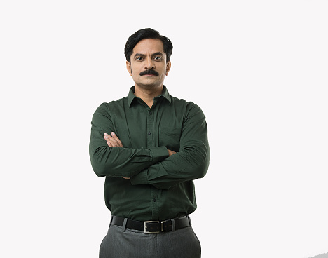 Portrait of smiling confident Indian male entrepreneurs in business wear with arms crossed standing against isolated white background