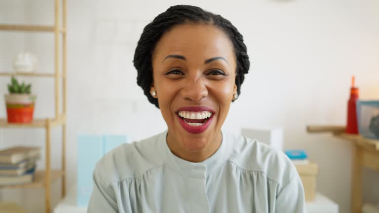 Portrait of smiling African-American businesswoman while having a video conference at her office