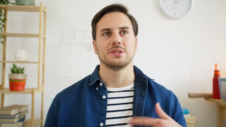 Portrait of young Caucasian businessman while having a video conference at his office