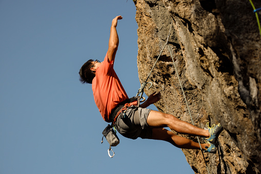 Man enjoys challenging rock climbing on limestone wall