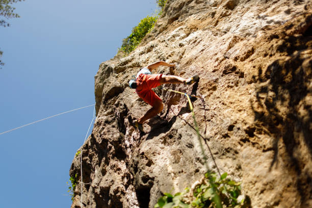 istock man challenging rock climbing on limestone wall 1446038605